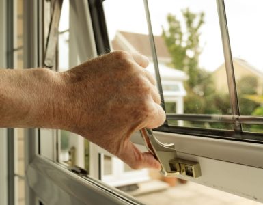 Zoom sur la main d'un homme ouvrant une fenêtre