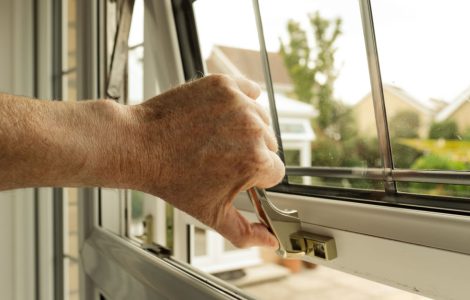 Zoom sur la main d'un homme ouvrant une fenêtre
