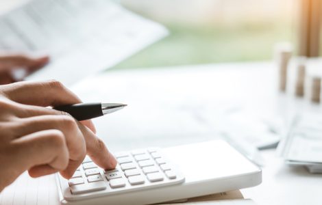 Zoom sur la main d'une personne tapotant une machine à calculer