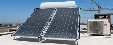 Panneaux solaires placés sur un toit d'immeuble à côté d'un climatiseur