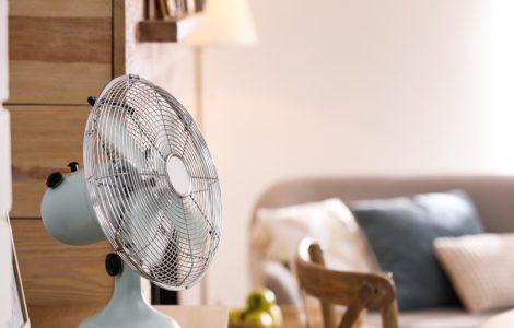 Focus sur unentilateur électrique posé sur une table en bois dans le salon