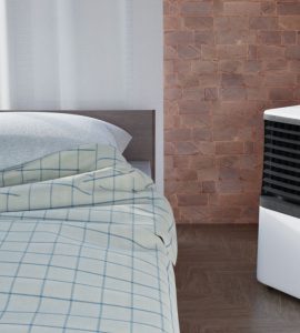 Un climatiseur portable placé à côté d'un lit