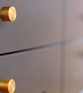 Focus sur les petits boutons en laiton des tiroirs d'une cuisine gris