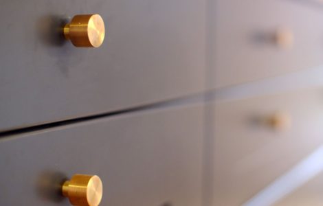 Focus sur les petits boutons en laiton des tiroirs d'une cuisine gris