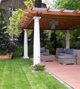 Canapé d'extérieur placé sous une tonnelle de jardin