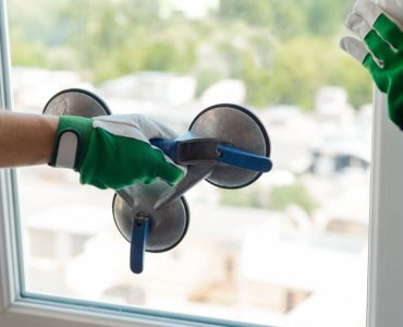 Zoom sur une main tenant un outil spécial pour porter une vitre de la fenêtre