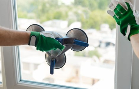 Zoom sur une main tenant un outil spécial pour porter une vitre de la fenêtre