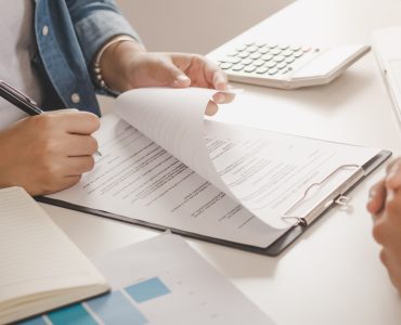 Une femme signant un contrat devant un agent