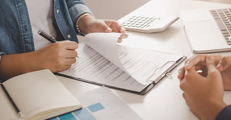 Une femme signant un contrat devant un agent