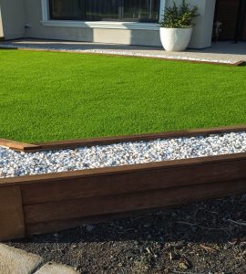 Pelouse artificielle avec bordure en bois et gravier