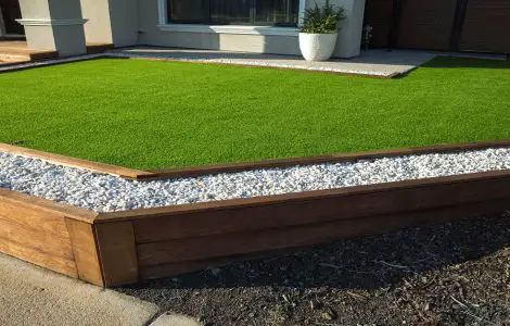 Pelouse artificielle avec bordure en bois et gravier