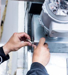 Un homme répare le système de ventilation