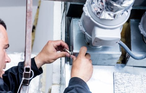 Un homme répare le système de ventilation