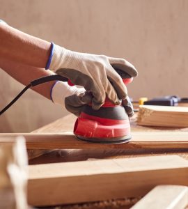 Une personne en train de poncer du bois dans un atelier de bricolage