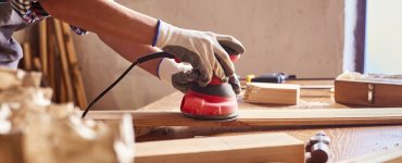 Une personne en train de poncer du bois dans un atelier de bricolage