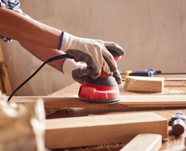 Une personne en train de poncer du bois dans un atelier de bricolage