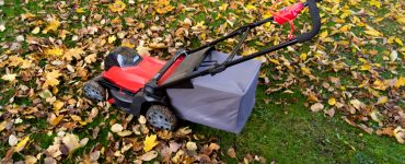 Une tondeuse de jardin sur une pelouse recouverte de feuilles