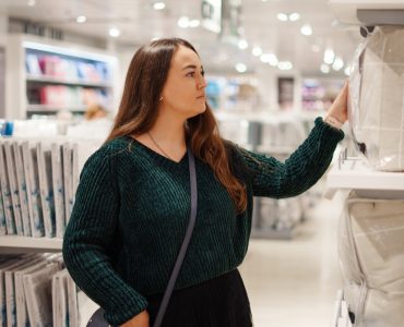 Une femme concentrée sur un article dans le rayon literie
