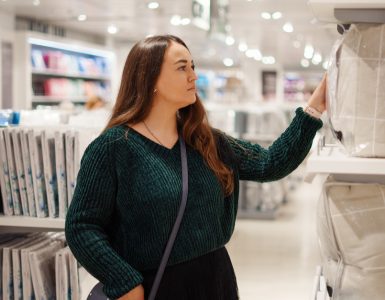 Une femme concentrée sur un article dans le rayon literie