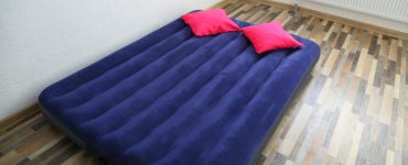 Un matelas gonflable bleu posé sur le parquet