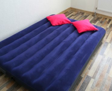 Un matelas gonflable bleu posé sur le parquet