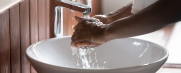 Une personne se lavant les mains dans le lavabo