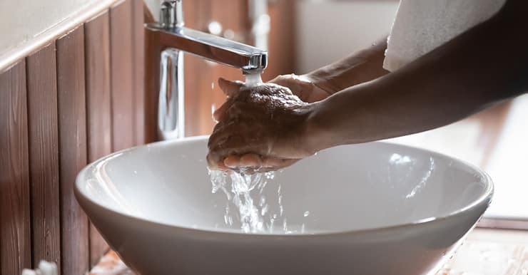 Une personne se lavant les mains dans le lavabo