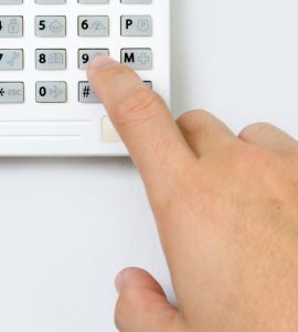 Gros plan sur une main composant les codes d'une alarme de sécurité