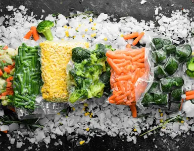 Différents légumes congelés dans des sacs en plastique transparents