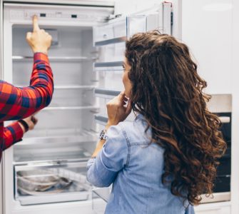 Un homme et une femme choisissant un frigo dans un magasin d'électroménagers
