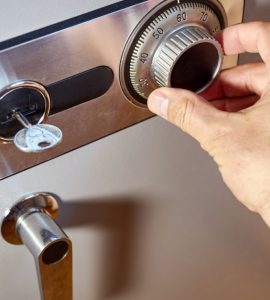 Zoom sur la main d'un homme entrant le code d'un coffre-fort