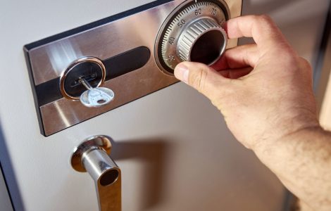 Zoom sur la main d'un homme entrant le code d'un coffre-fort