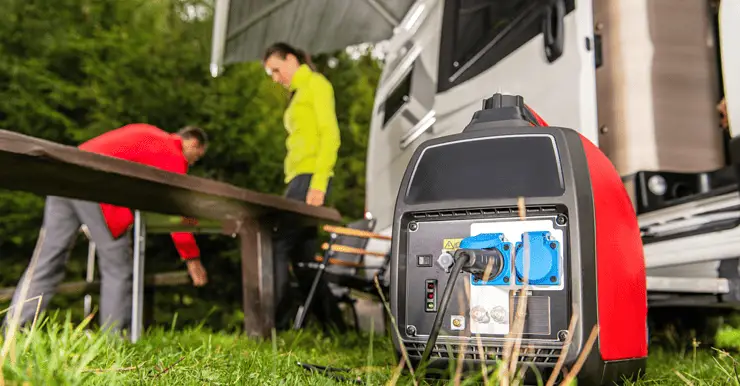 Un groupe électrogène posé sur le gazon avec une femme et un homme en fond