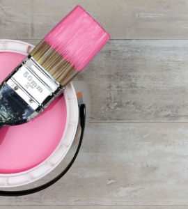 Vue de dessus sur un pot de peinture rose et un pinceau