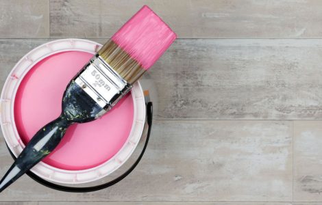 Vue de dessus sur un pot de peinture rose et un pinceau
