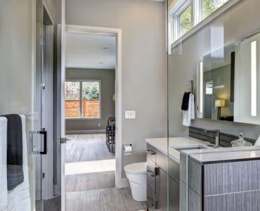 Une salle de bain moderne grise avec un grand miroir