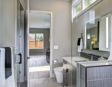 Une salle de bain moderne grise avec un grand miroir