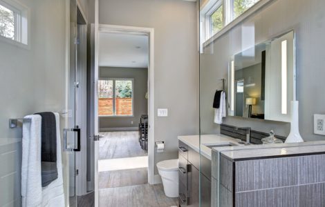 Une salle de bain moderne grise avec un grand miroir