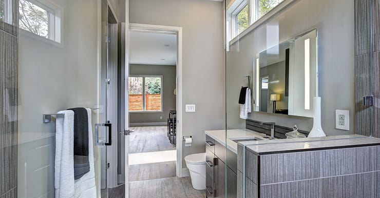 Une salle de bain moderne grise avec un grand miroir