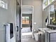 Une salle de bain moderne grise avec un grand miroir