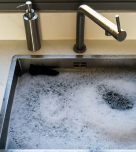 Evier bouché, rempli d'eau savonneuse