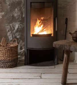 Un panier en osier posé près d'une cheminée allumée