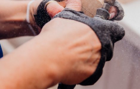 Une femme travaillant du bois avec une petite ponceuse électrique