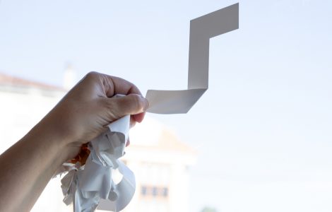 Gros plan sur une main enlevant un autocollant sur la vitre d'une fenêtre