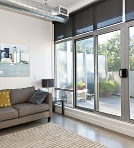 Salon avec porte coulissante en verre donnant une vue sur le balcon