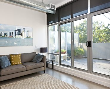 Salon avec porte coulissante en verre donnant une vue sur le balcon