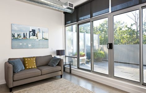 Salon avec porte coulissante en verre donnant une vue sur le balcon