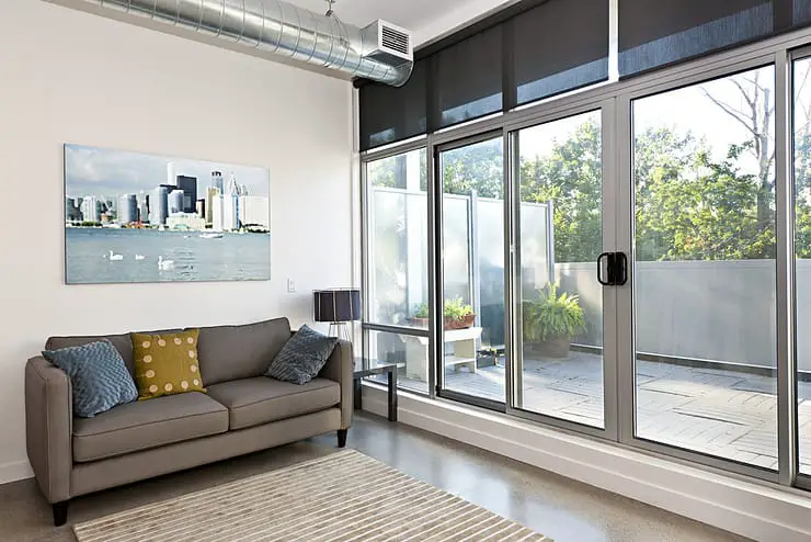 Salon avec porte coulissante en verre donnant une vue sur le balcon