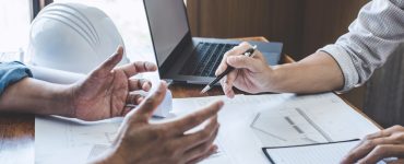 Deux hommes discutent dans un bureau à propos d'un chantier