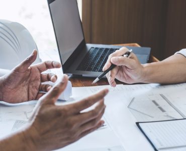 Deux hommes discutent dans un bureau à propos d'un chantier